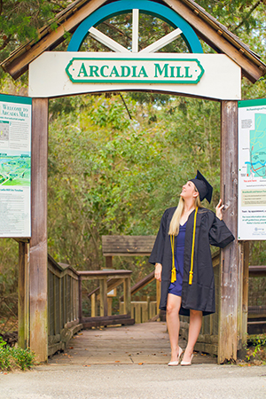 student standing under arcadia sign