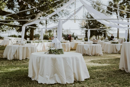 Barkley House yard space set up for an outdoor wedding reception with elegant white linens